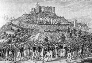 men and women marching to the ruined castle on top of a hill
