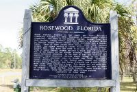 A color photograph of the front of the bronze plaque in Rosewood next to the highway
