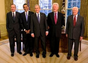 Group portrait of five men in dark suits and ties